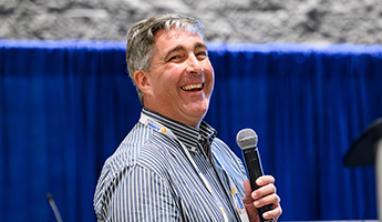 a man speaking into a microphone happily