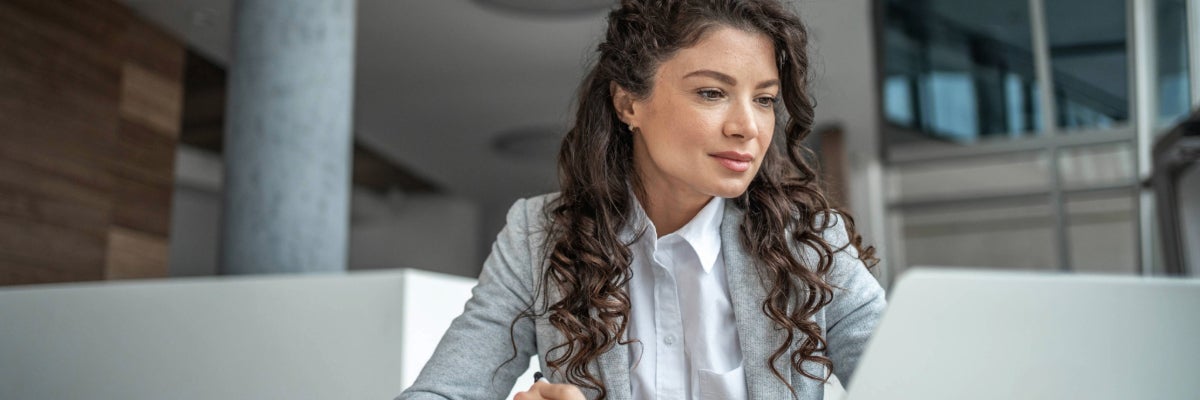 Woman sitting down on a laptop. 