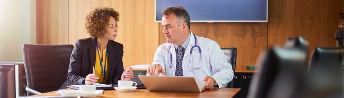 man and woman talking in a boardroom